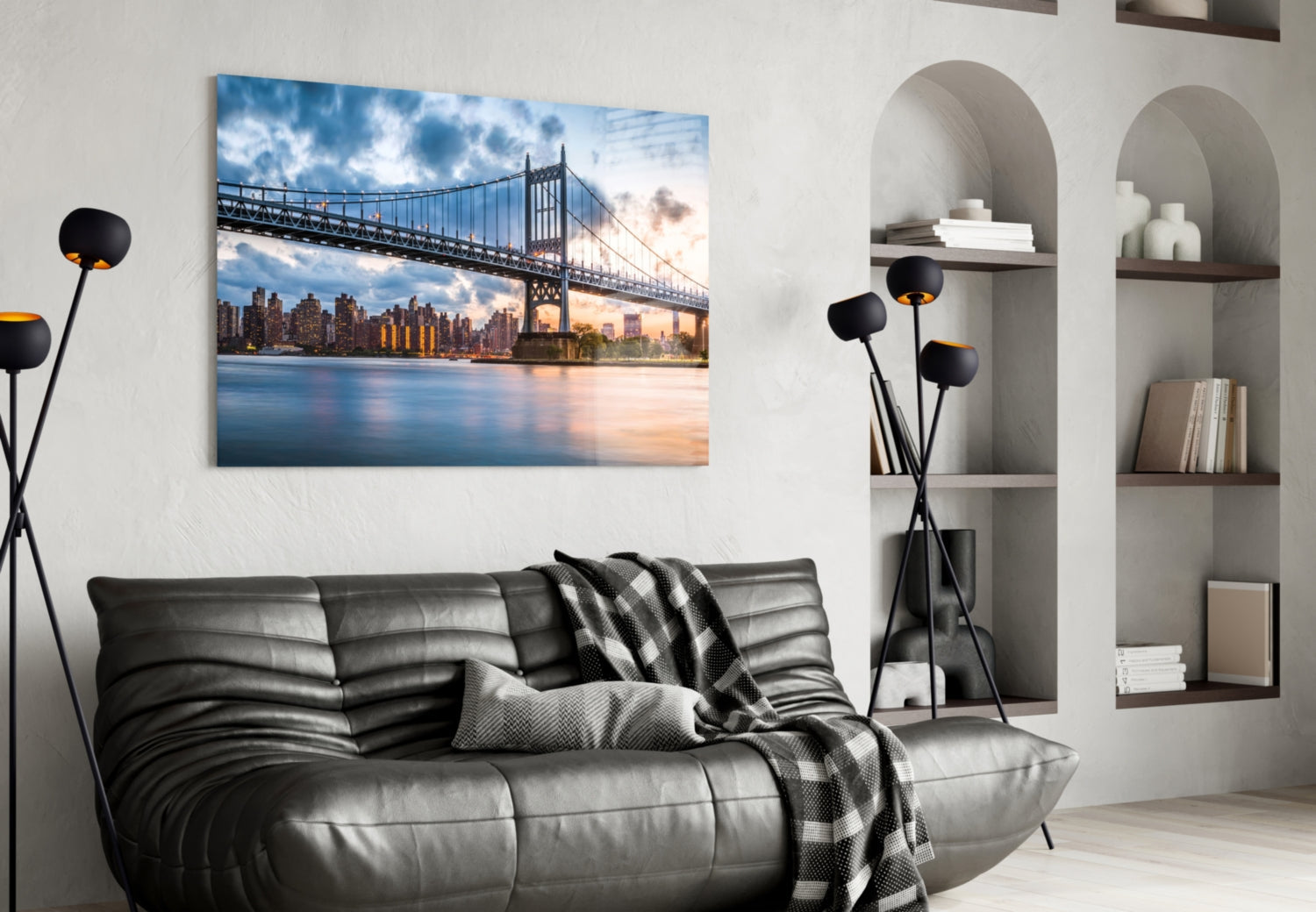 Glass wall art featuring the Queensboro Bridge and Manhattan skyline at sunset, displayed above a black leather sofa in a modern living room.