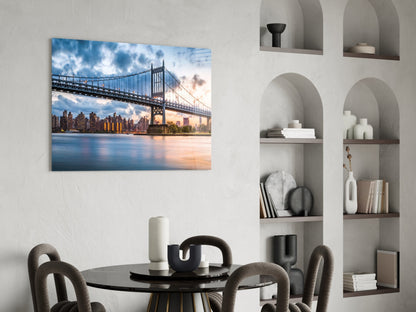 Glass wall art depicting Queensboro Bridge at sunset with Manhattan skyline, displayed above black dining table in modern interior.