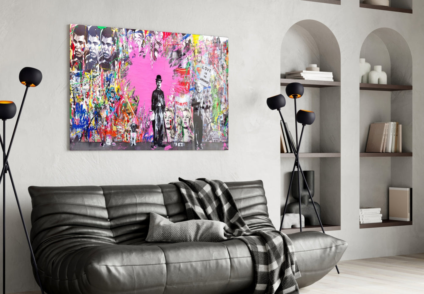 Colorful pop art glass wall panel with pink background and graffiti-style figures displayed above black leather sofa in modern living room.