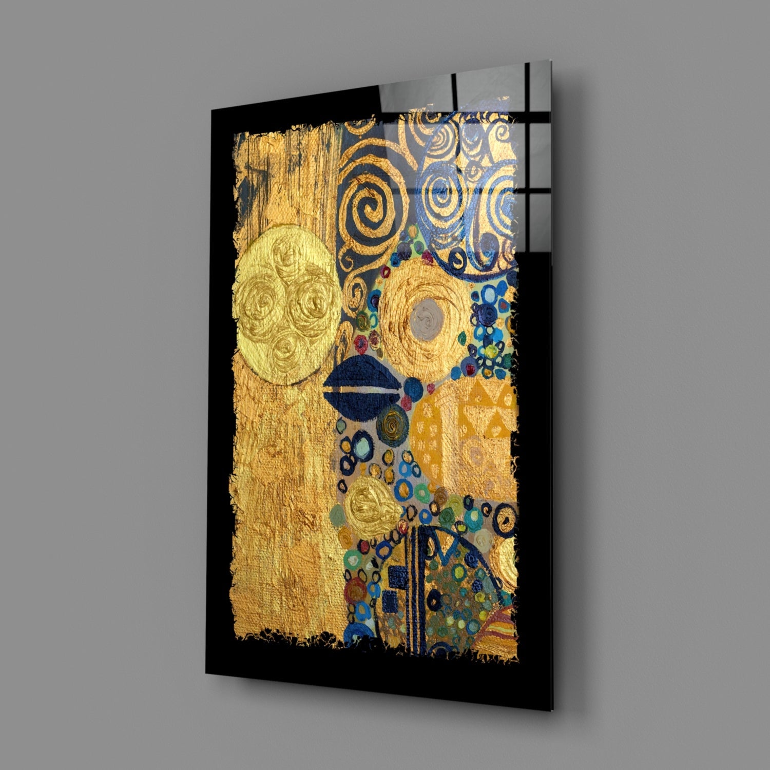 Angled view of gold and blue abstract glass wall art with spiral patterns and geometric shapes mounted on black backing.