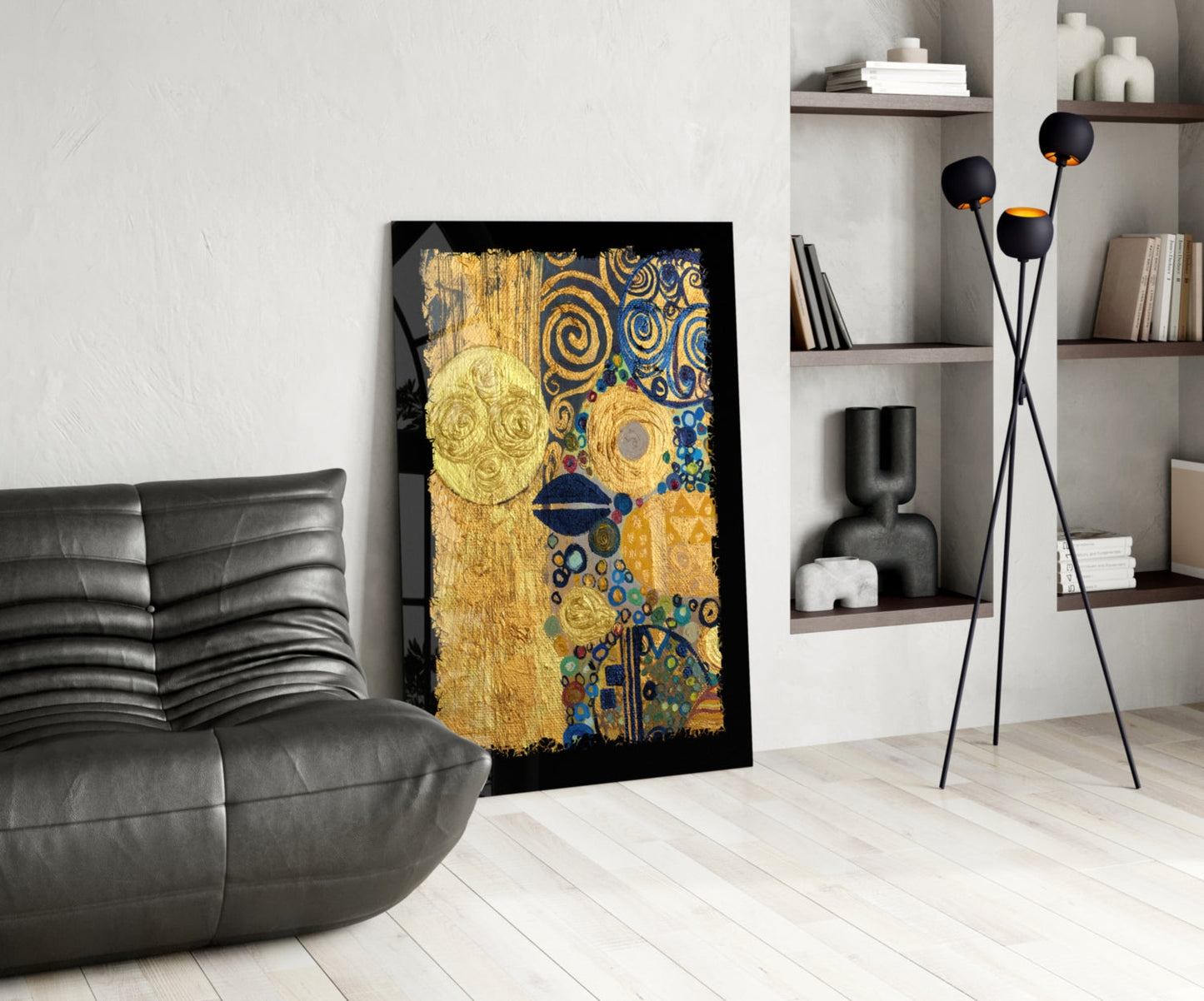 Gold abstract glass wall art with blue and colorful circular patterns displayed in modern living room next to black leather sofa.