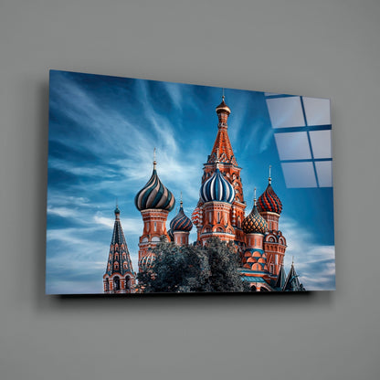St. Basil's Cathedral glass wall art displayed at an angle against gray wall, showing red brick cathedral with colorful onion domes and blue sky.
