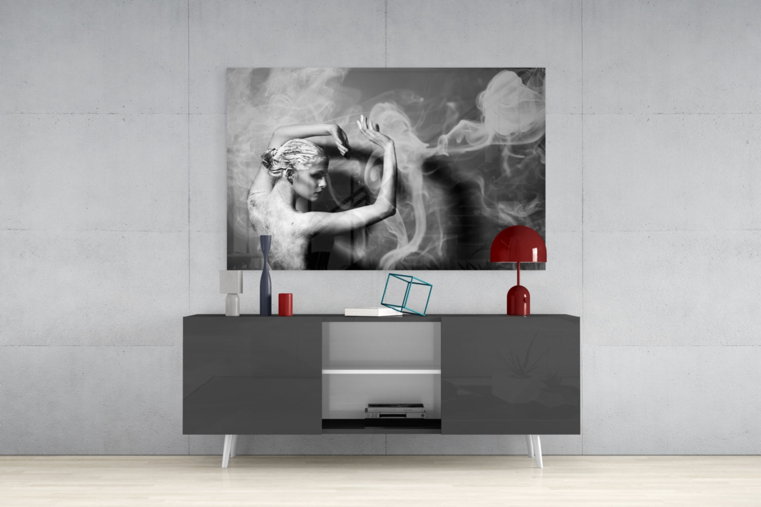 Black and white glass wall art depicting a classical figure with flowing smoke effects, displayed above a dark media console with red decorative accessories.