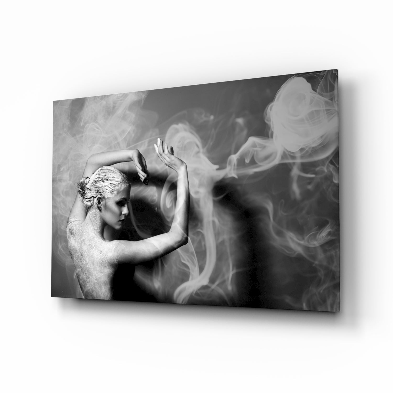 Black and white glass wall art depicting a profile of a woman with arms raised, surrounded by swirling smoke effects, displayed at an angle.