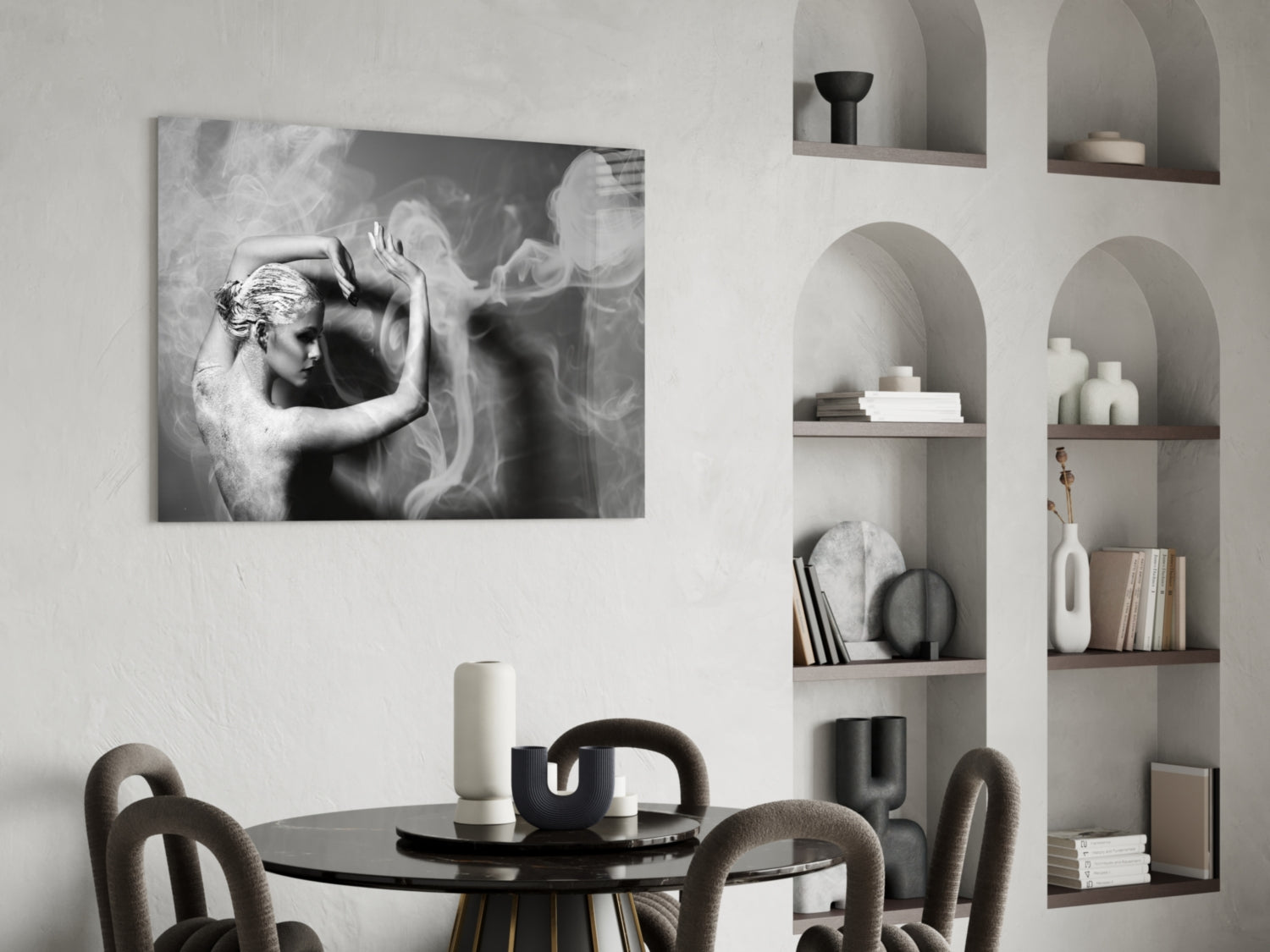 Black and white glass wall art depicting a woman with flowing fabric, displayed above a round dining table with curved chairs and built-in shelving.
