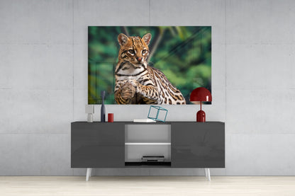 Cheetah glass wall art mounted above gray media console, displaying spotted big cat against green blurred background.
