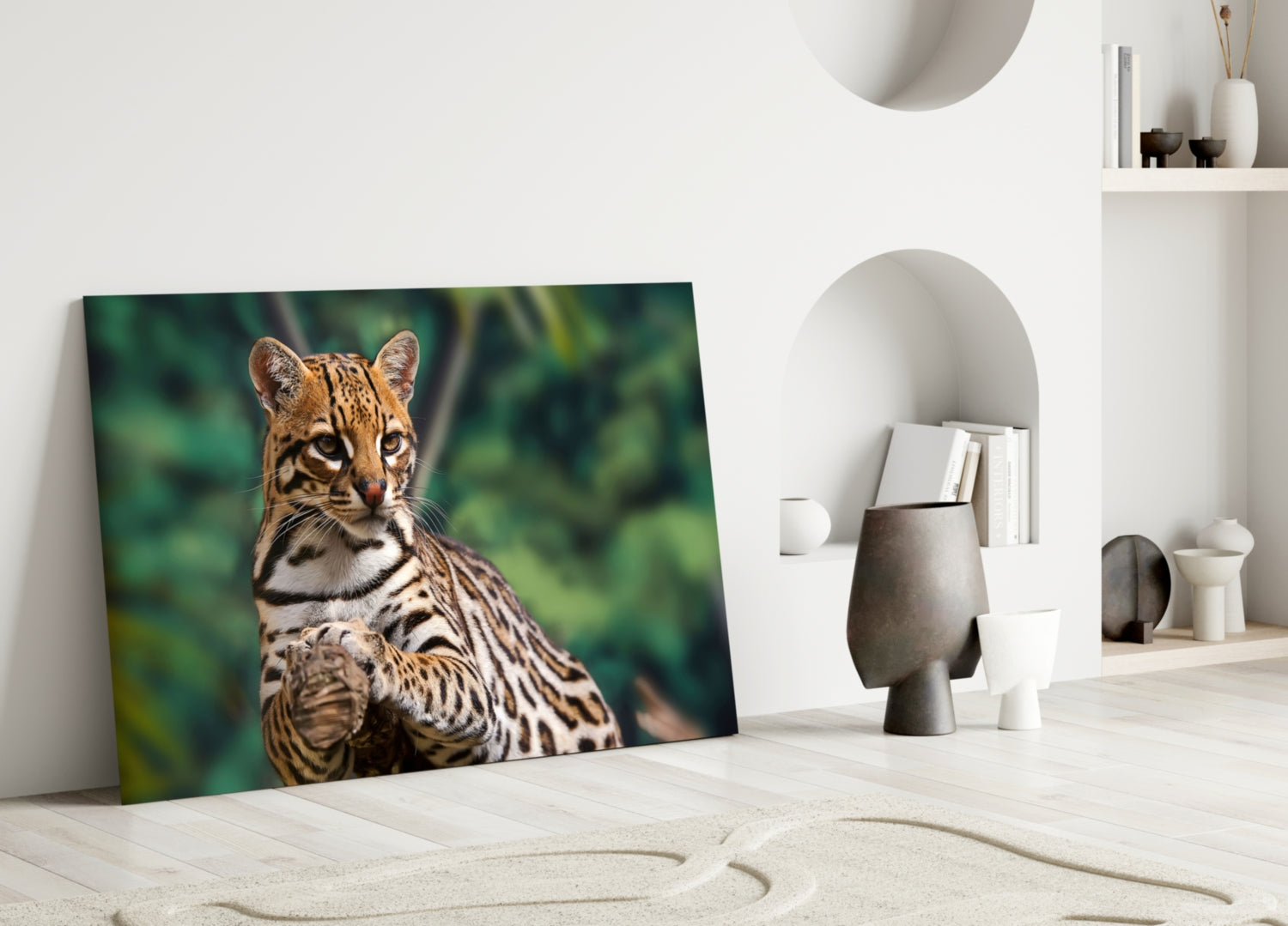 Glass wall art featuring a spotted wild cat with green foliage background, leaning against white interior wall shelf.