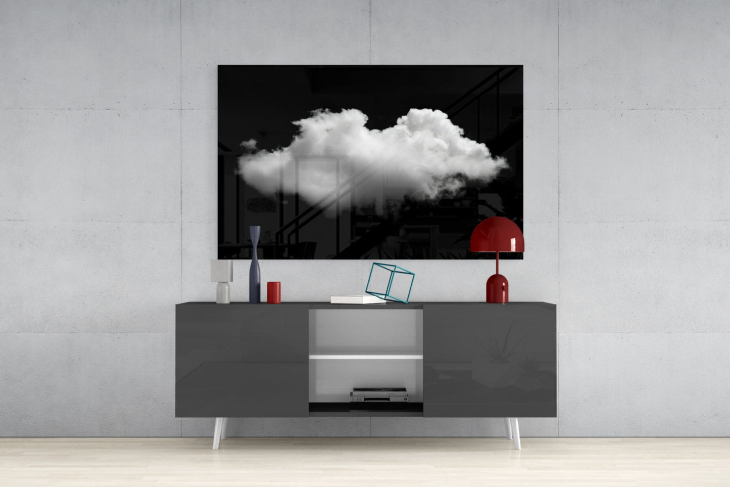 Black and white cloud glass wall art displayed above gray media console with red lamp and decorative objects in modern interior setting.