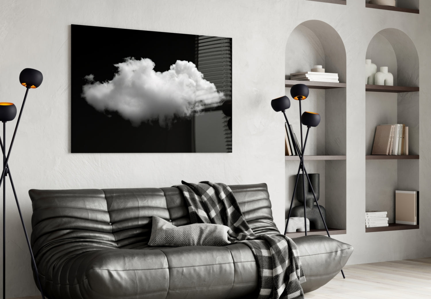 Black framed glass wall art displaying a white cloud against dark background, displayed above gray leather sofa in modern living room.
