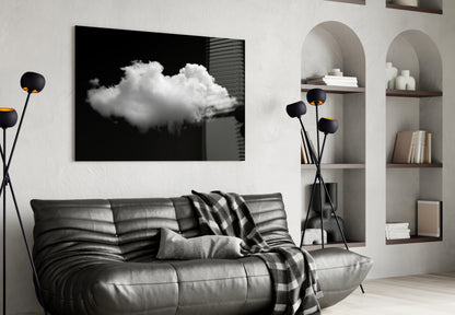 Black framed glass wall art displaying a white cloud against dark background, displayed above gray leather sofa in modern living room.