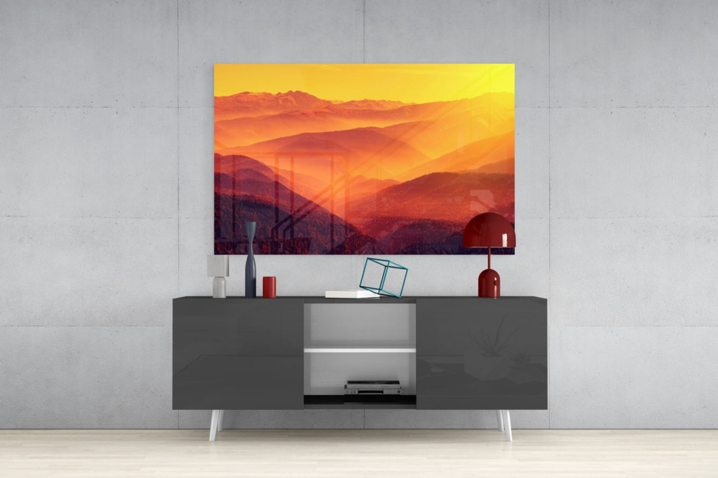 Warm Landscape Glass Wall Art displaying golden sunset mountains mounted above gray media console with decorative accessories.