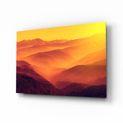 Layered mountain landscape at sunset printed on glass wall art, transitioning from deep red forested foreground to golden yellow sky.