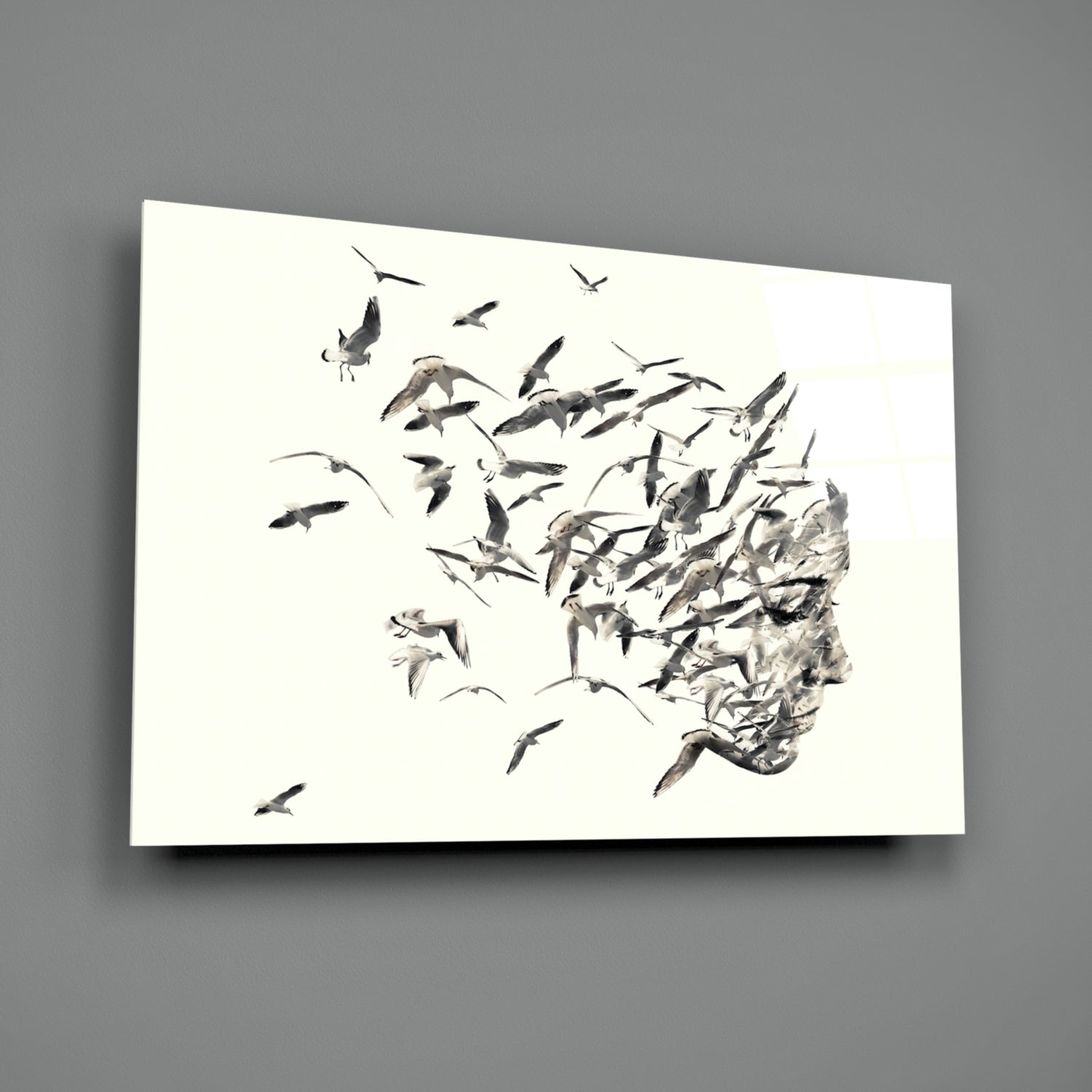 Glass wall art panel displaying a monochromatic illustration of birds flying away from a textured human head profile against a white background.