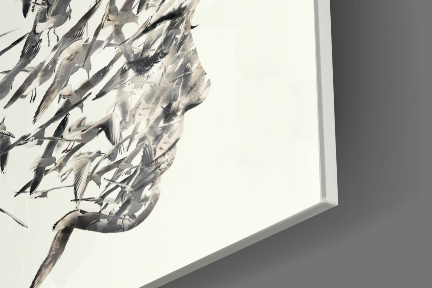 Close-up of textured glass wall art featuring black and gray brushstroke details against white background, mounted on gray wall.