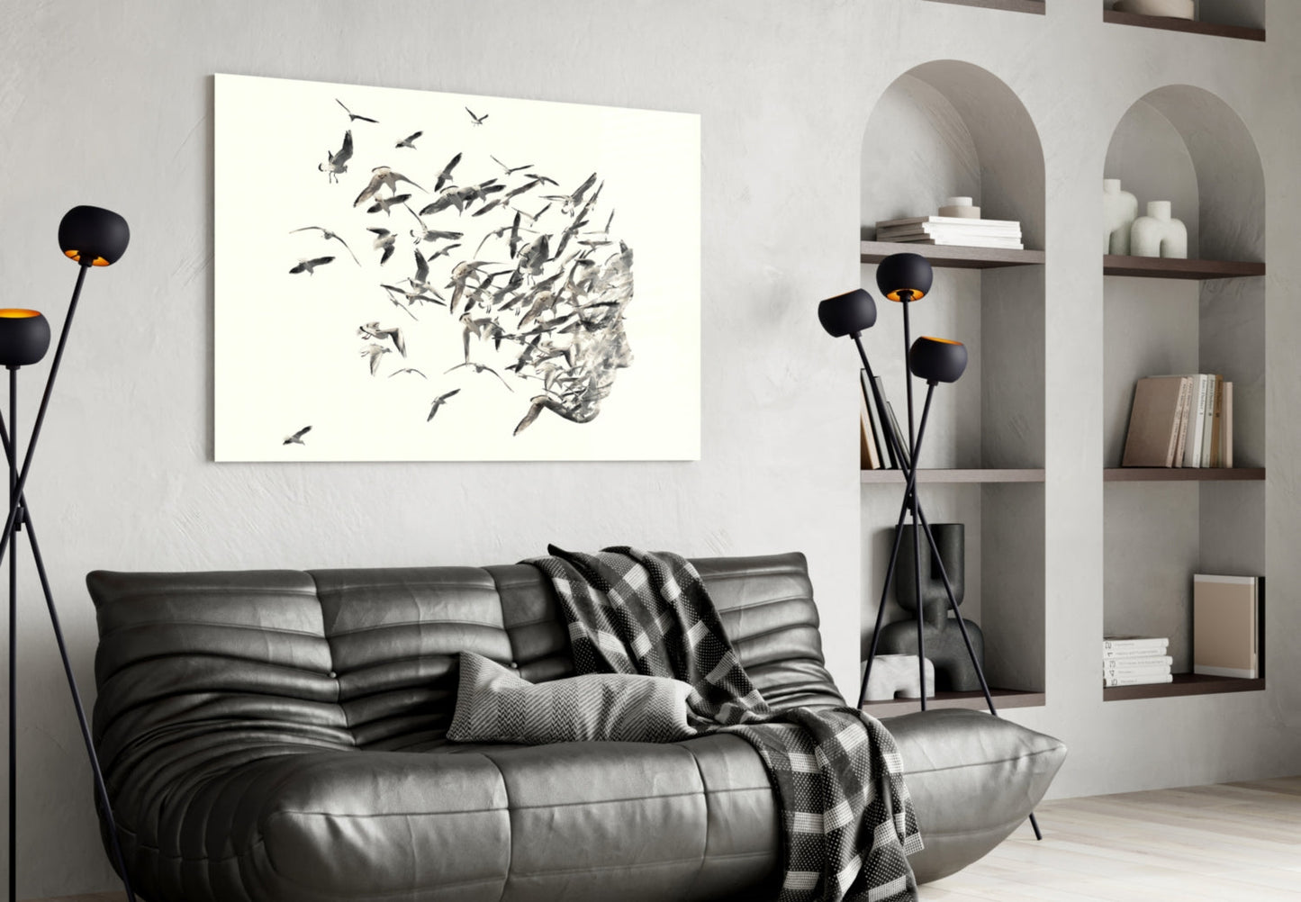 Modern living room with black leather sofa displaying horizontal glass wall art featuring birds dispersing from textured head silhouette.