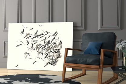 Modern living room interior featuring glass wall art with black ink drawing of birds dispersing from a human head silhouette.