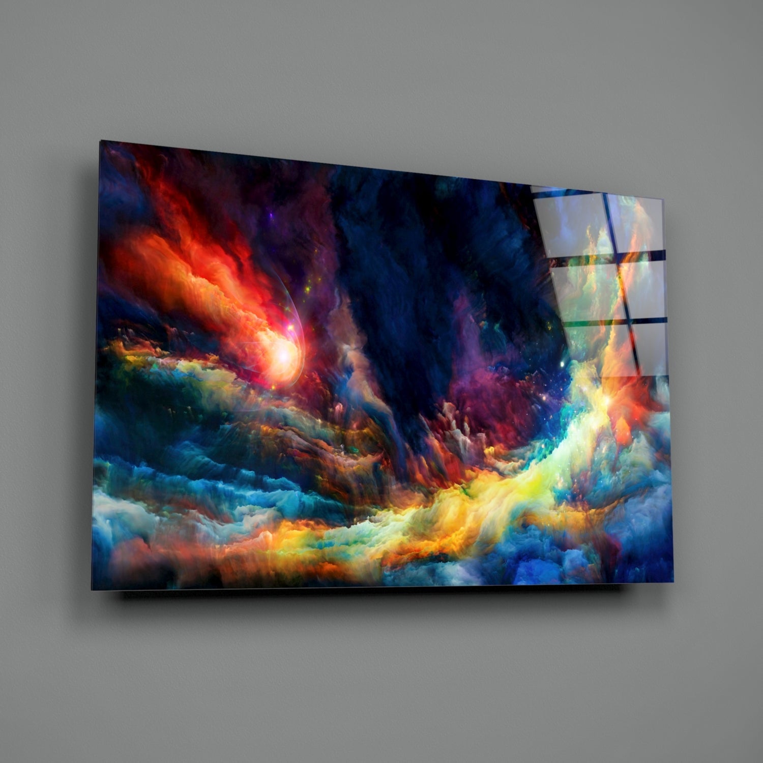 Vibrant glass wall art mounted on gray wall displaying swirling clouds in red, orange, yellow, blue, and purple hues with bright glowing center.