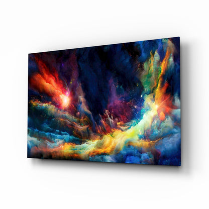 Angled view of a glass wall art panel displaying a vibrant cosmic nebula scene with red, orange, yellow, blue, and purple swirling clouds and bright light sources.