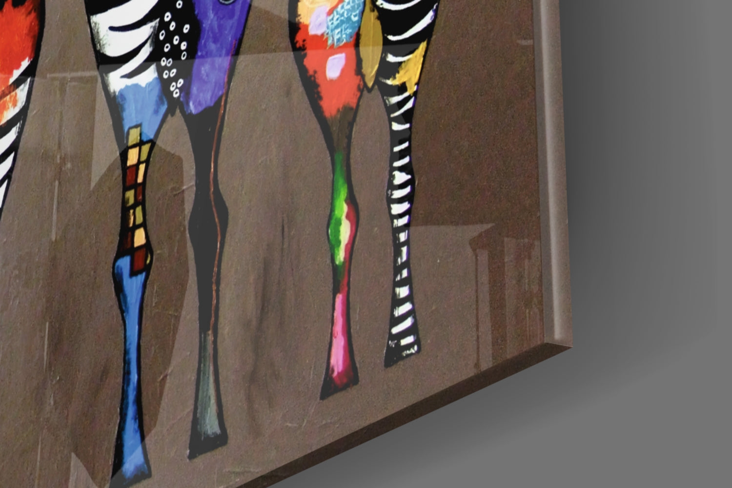 Close-up angled view of four hand-painted glass panels featuring colorful zebra stripe designs in vibrant reds, blues, greens, and blacks mounted on brown wall.