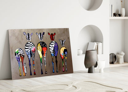 Colorful zebra glass wall art leaning against beige wall in minimalist interior with white shelving and decorative objects.