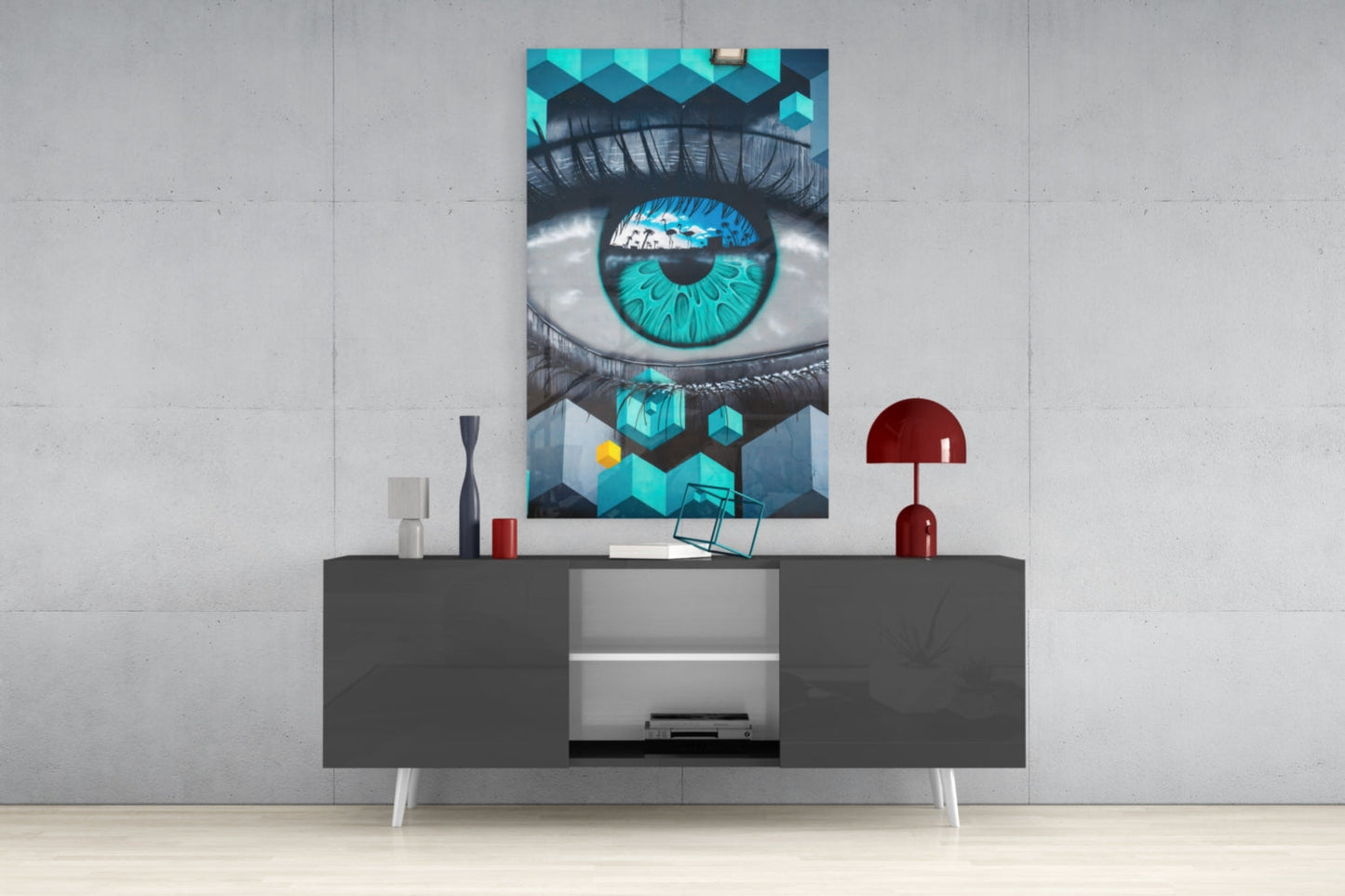 Turquoise eye glass art displayed on gray media console with decorative items in modern living room setting.