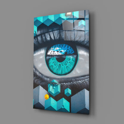 Angled product shot of turquoise eye glass wall art displaying a detailed blue iris with geometric patterns and tropical scene reflection.