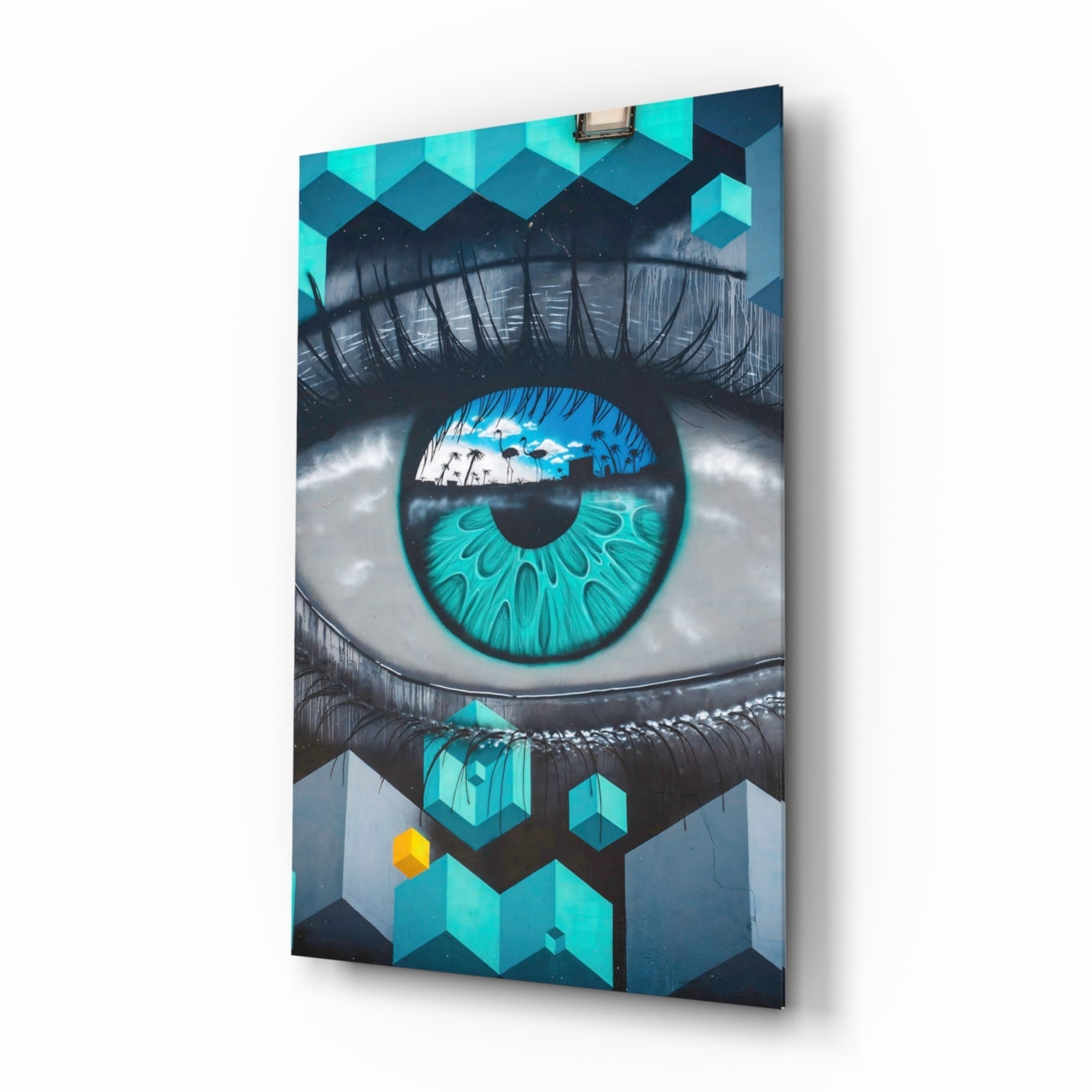 Glass wall art panel displaying a large turquoise eye with tropical scene reflection, geometric patterns, and yellow accent, shown at angled perspective.
