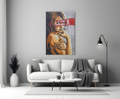 Glass wall art depicting a portrait of a child with a red censorship bar across the eyes, displayed above a white sofa in a minimalist living room.