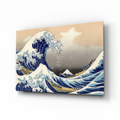 Glass wall art print displayed at an angle showing Hokusai's Great Wave with blue and white waves, Mount Fuji, and cream background.