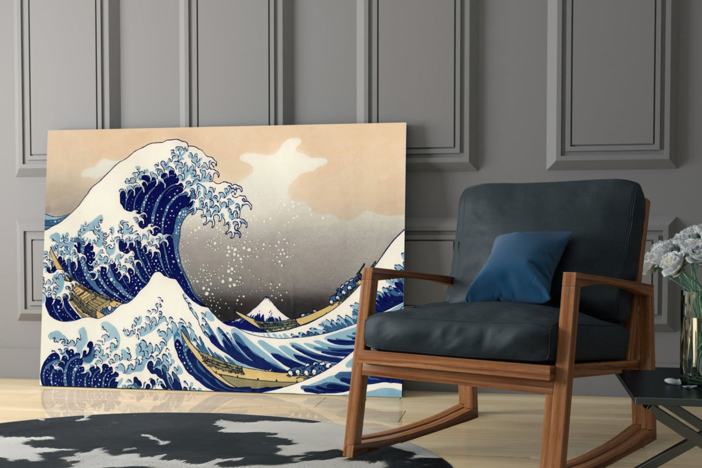 Glass wall art displaying Hokusai's Great Wave print in blue and cream tones, positioned beside a wooden rocking chair in a modern interior.