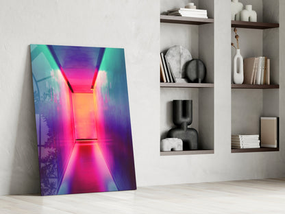 Neon tunnel glass wall art with vibrant pink, magenta, and cyan gradient lighting leaning against white wall beside shelving.