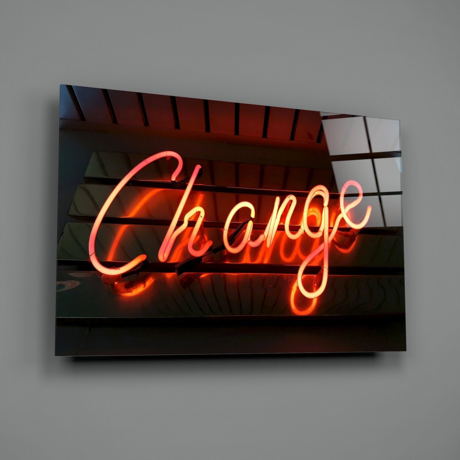 Neon "Change" sign glowing red and orange on black glass panel mounted on gray wall.