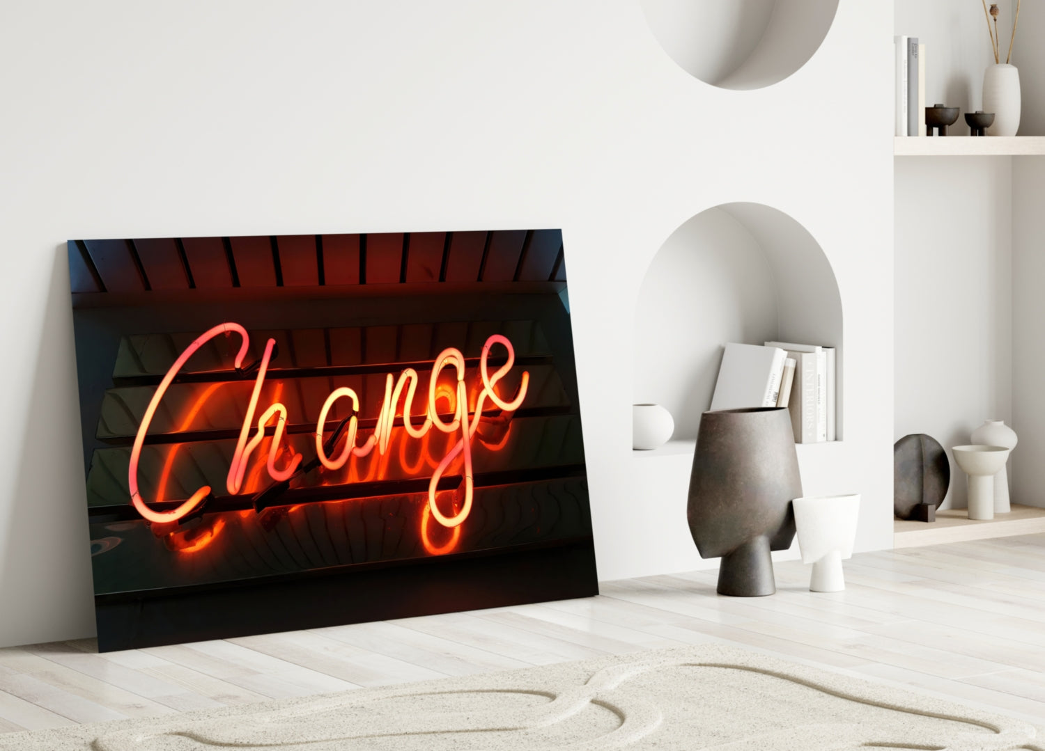 Neon "Change" glass wall art leaning against white wall in minimalist interior with shelving and decorative objects.