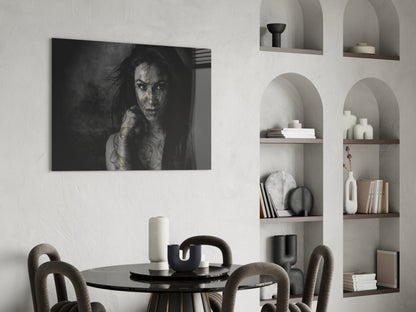 Black and white glass wall art of tattooed woman displayed above round dining table in modern interior setting.