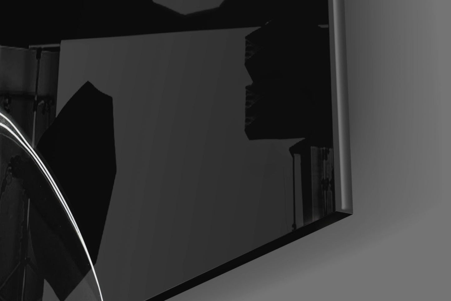 Close-up angled view of black glass hourglass wall art mounted on white wall, showing silhouette profile detail.