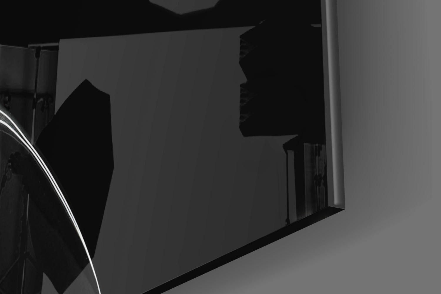 Close-up angled view of black glass hourglass wall art mounted on white wall, showing silhouette profile detail.