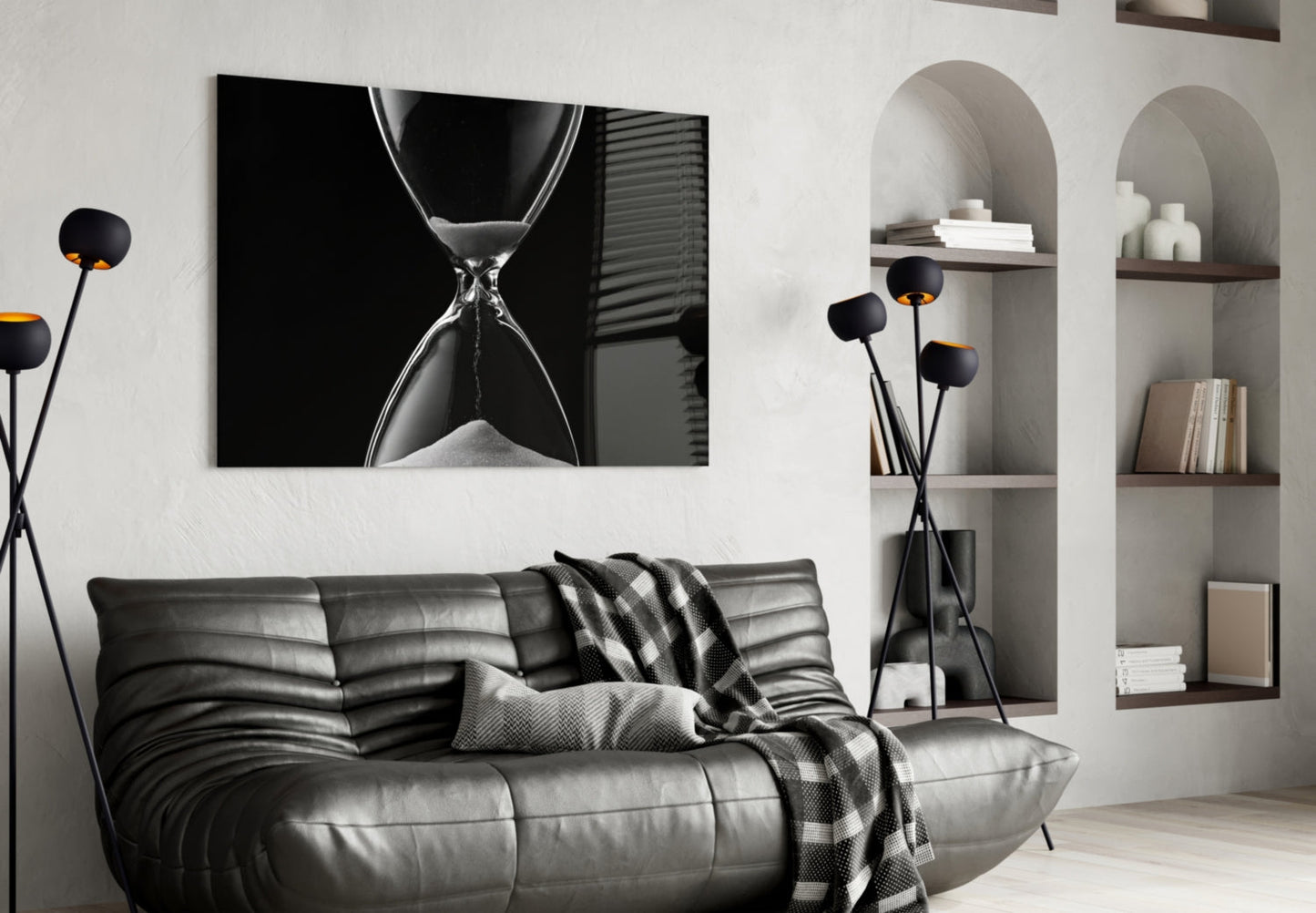 Black and white hourglass artwork displayed above a gray leather sofa in a modern living room with built-in shelving.