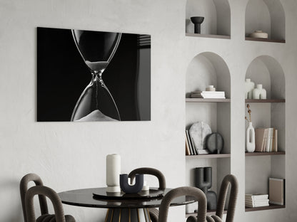 Black and white hourglass canvas art displayed above a round black dining table with upholstered chairs and styled wall shelving.