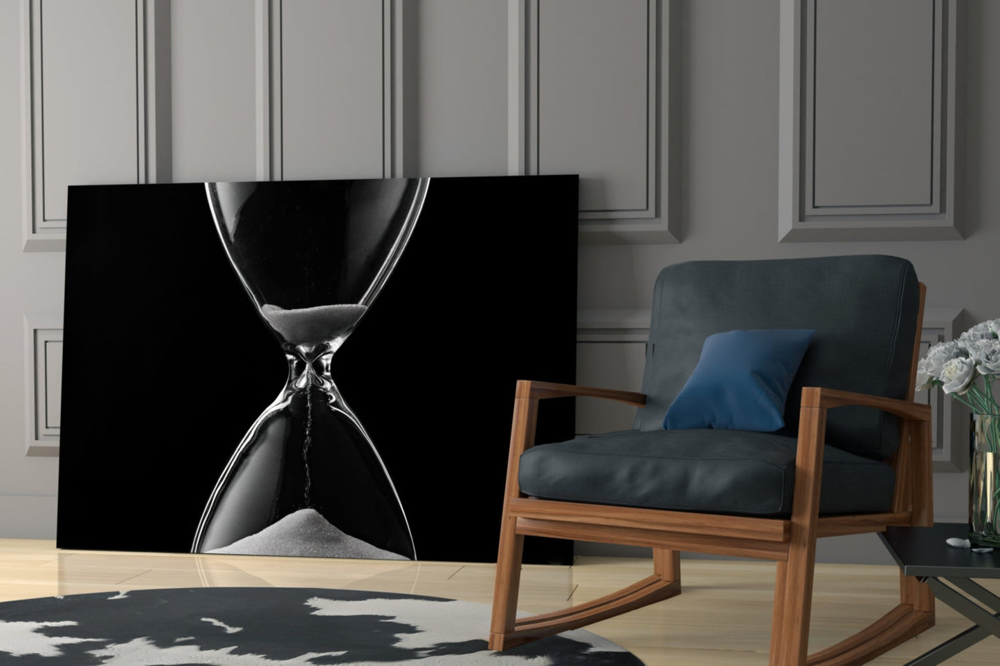 Black and white hourglass wall art displayed in modern living room with wooden chair and blue cushions.