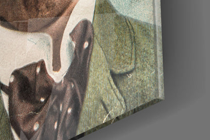 Close-up angled view of glass wall art showing brown fabric texture and green textile detail with white border.