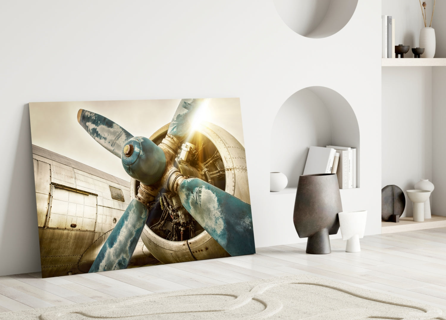Vintage airplane propeller glass wall art leaning against white wall in minimalist interior setting.