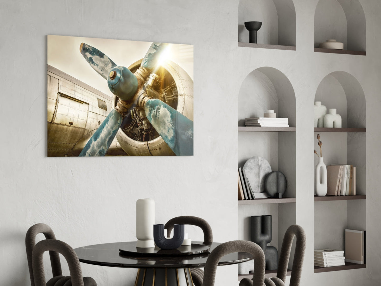 Close-up of vintage aircraft propeller with weathered blue-green blades and golden engine housing, displayed on living room wall above dining table.