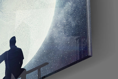 Silhouetted figure viewing large textured glass panel with speckled blue gradient surface against white wall.