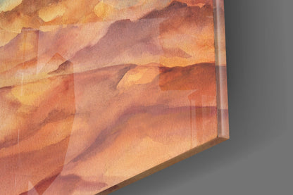 Angled close-up of glass wall art showing warm watercolor mountain landscape in orange, peach, and brown tones with visible glass edge.