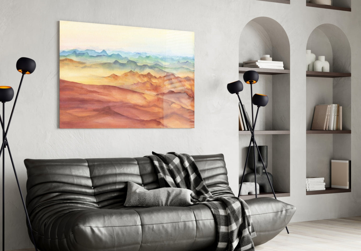 Abstract mountain landscape glass wall art with warm gradient colors displayed above a black leather sofa in a modern living room.