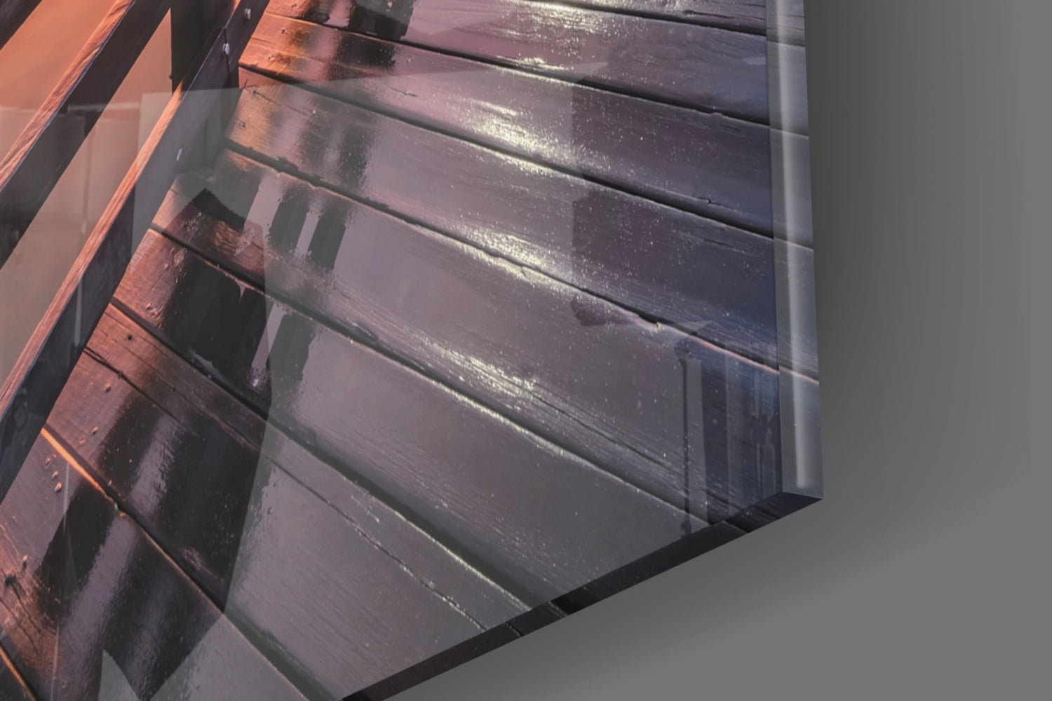 Close-up angled view of glass wall art showing horizontal panels with deep purple and orange gradient lighting reflecting on glossy surface.
