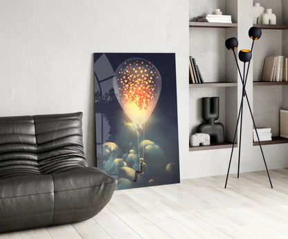Modern living room interior featuring glass wall art depicting a glowing bulb with golden stars above clouds and a silhouetted figure below.