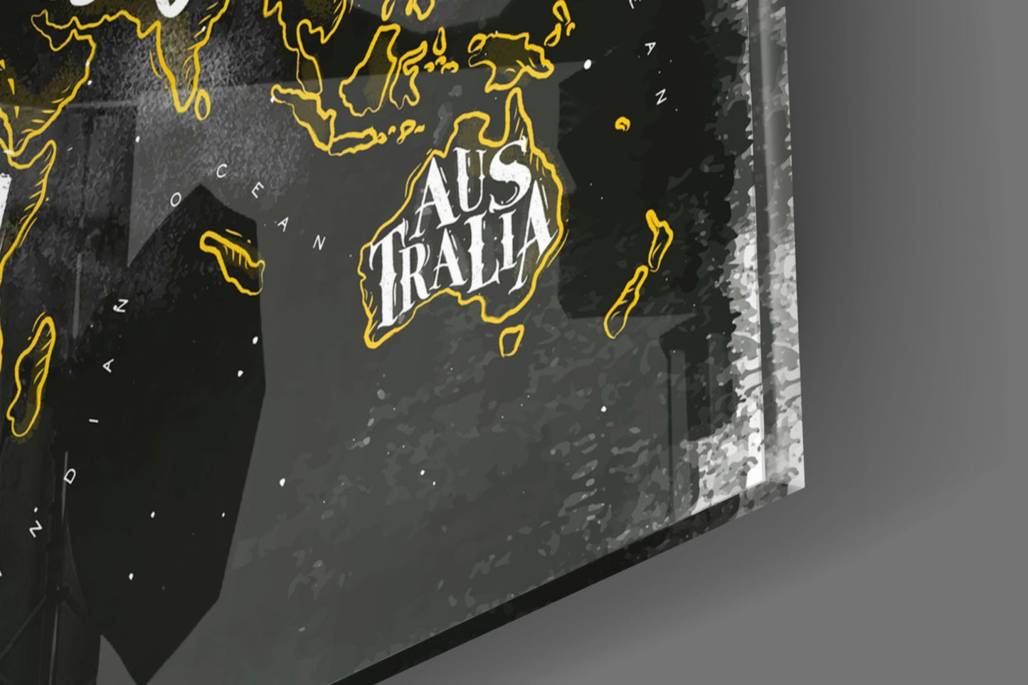 Close-up angled view of a modern world map with yellow outlined continents and "Australia" text on dark background, displayed on textured surface.