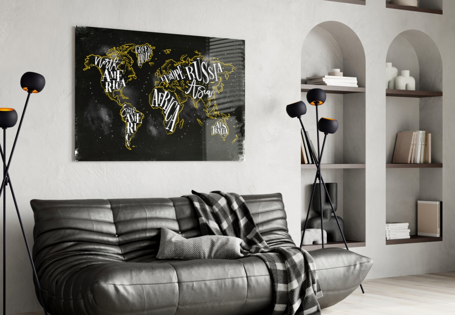 Black canvas world map with gold outlined continents and white lettering displayed above gray leather sofa in modern living room.