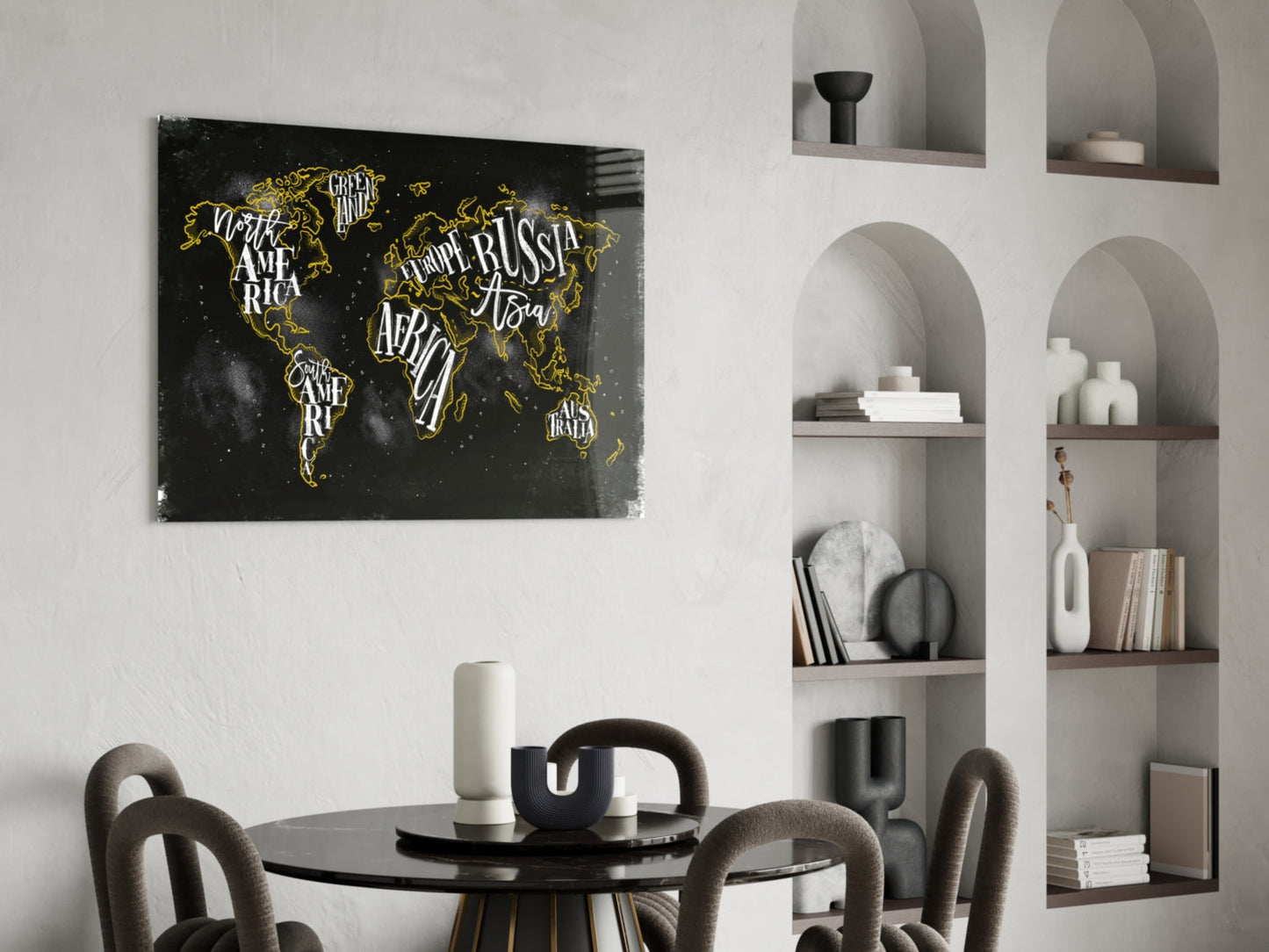 Black world map canvas with gold lettering displayed above round dining table in minimalist interior.